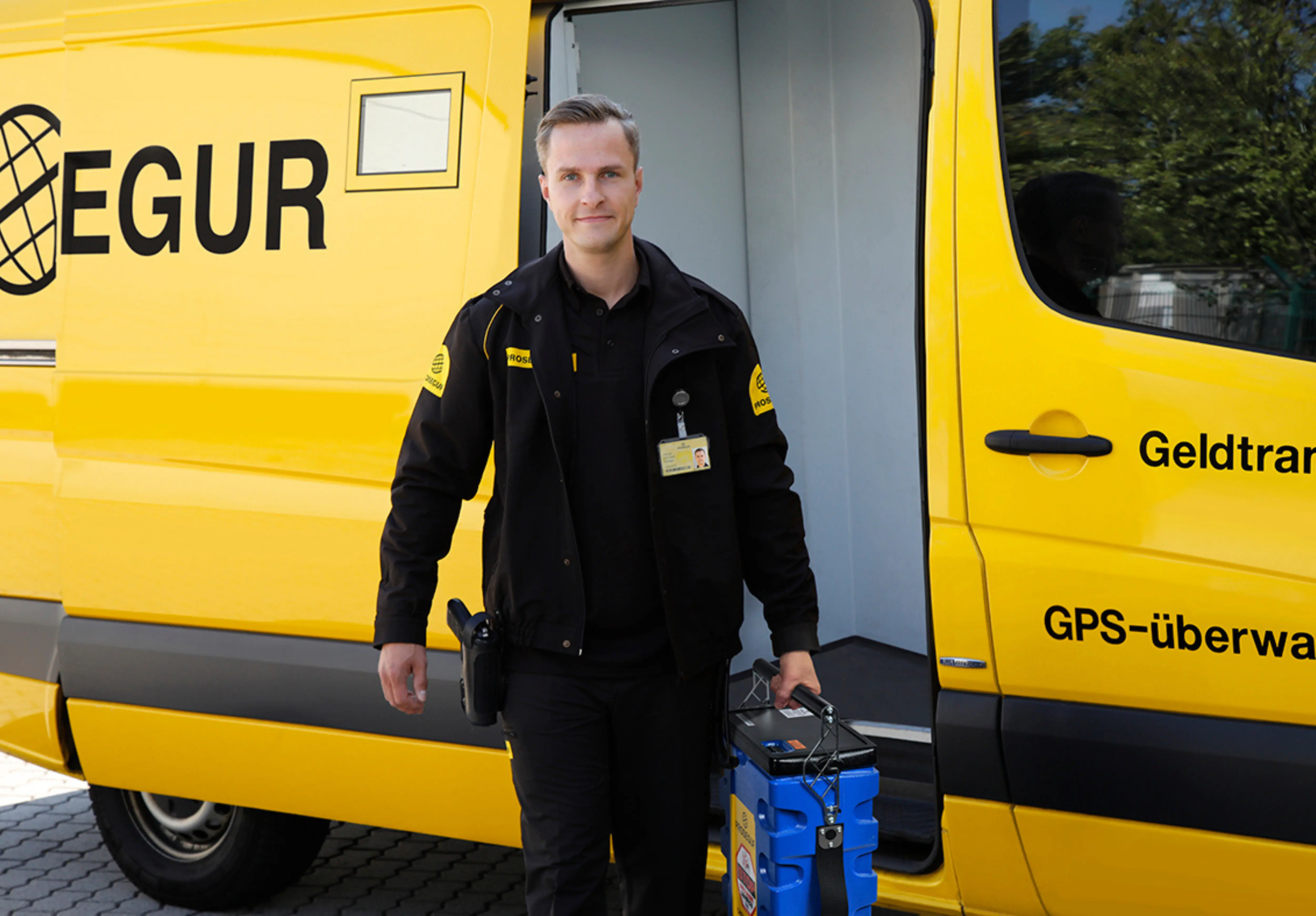 Geldbote steigt mit Transportsicherungsgerät aus Prosegur-Geldtransporter aus
